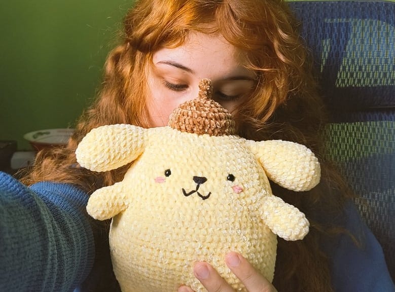 Artesã Rayssa segurando um Amigurumi
